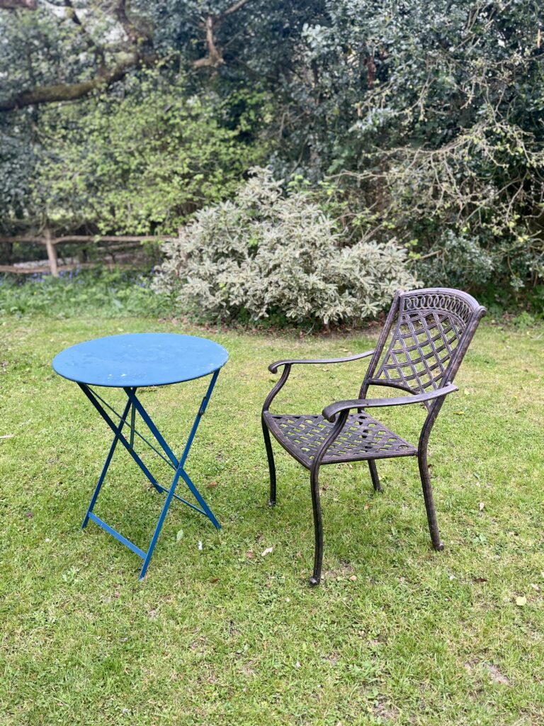 Quiet garden scene with a chair and table, used on the Beyond Imposter Syndrome page to reflect leadership coaching and inner confidence.